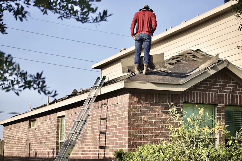 Professional roofer working on a residential roof in Hinsbrook